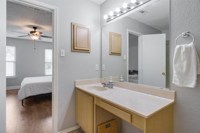 5012 Marina Del Rd, Fort Worth, TX 76179 - bathroom with wood finished floors, a textured ceiling, a ceiling fan, connected bathroom, and vanity