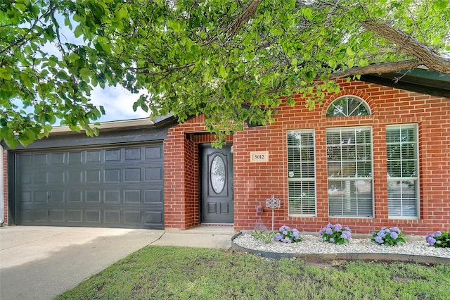 5012 Marina Del Rd, Fort Worth, TX 76179 - view of exterior entry with driveway, a garage, and brick siding