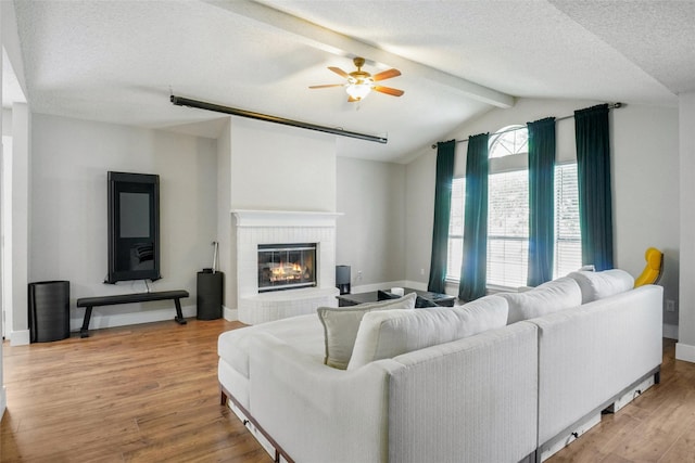5012 Marina Del Rd, Fort Worth, TX 76179 - living area with a ceiling fan, light wood finished floors, baseboards, a brick fireplace, and a textured ceiling