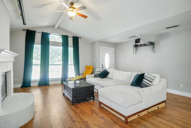 5012 Marina Del Rd, Fort Worth, TX 76179 - living area featuring a textured ceiling, ceiling fan, wood finished floors, a fireplace, and baseboards
