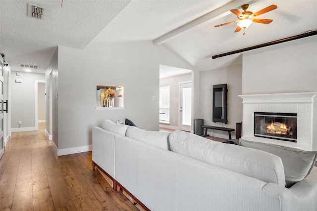 5012 Marina Del Rd, Fort Worth, TX 76179 - living room with wood-type flooring, a brick fireplace, baseboards, ceiling fan, and a textured ceiling