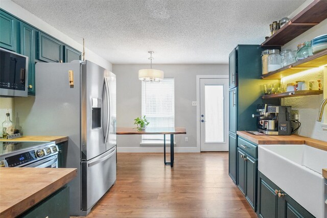 5012 Marina Del Rd, Fort Worth, TX 76179 - kitchen with butcher block counters, appliances with stainless steel finishes, a textured ceiling, light wood-type flooring, and a sink