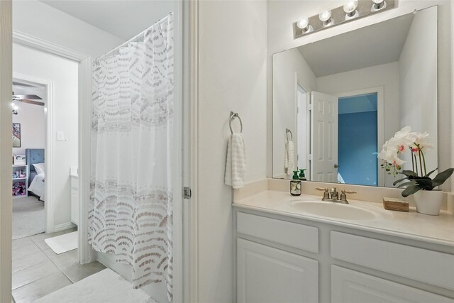 bathroom featuring tile patterned flooring, vanity, connected bathroom, and curtained shower