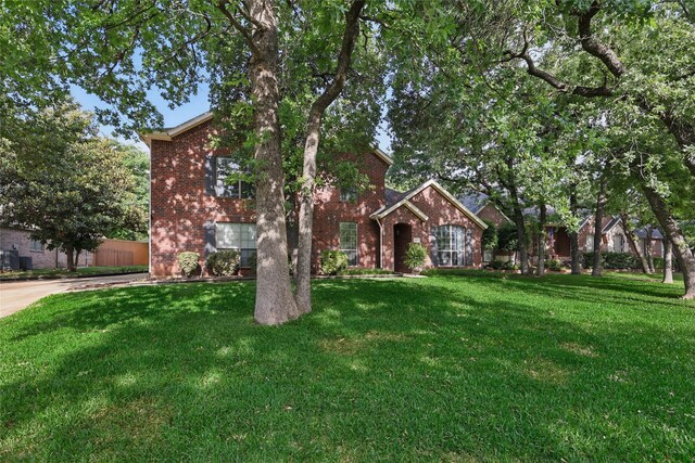 view of front of house with brick siding and a front lawn