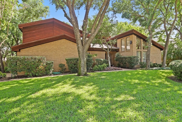 view of front of home with brick siding and a front lawn