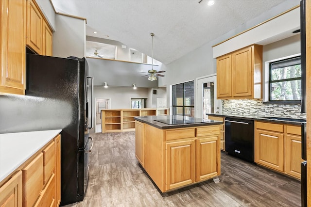 kitchen with black appliances, ceiling fan, vaulted ceiling, wood finished floors, and a kitchen island
