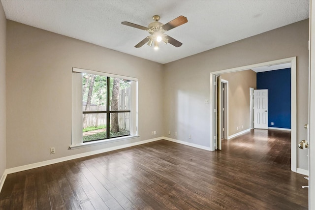 empty room with dark wood finished floors, ceiling fan, and baseboards
