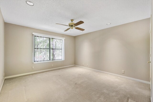 carpeted spare room with a textured ceiling, ceiling fan, baseboards, and recessed lighting