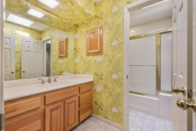 bathroom with tile patterned floors, wallpapered walls, vanity, and enclosed tub / shower combo