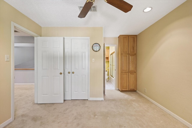 unfurnished bedroom with light colored carpet, baseboards, a closet, and a ceiling fan