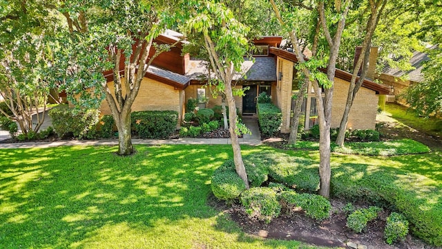 view of front facade featuring a front yard and brick siding