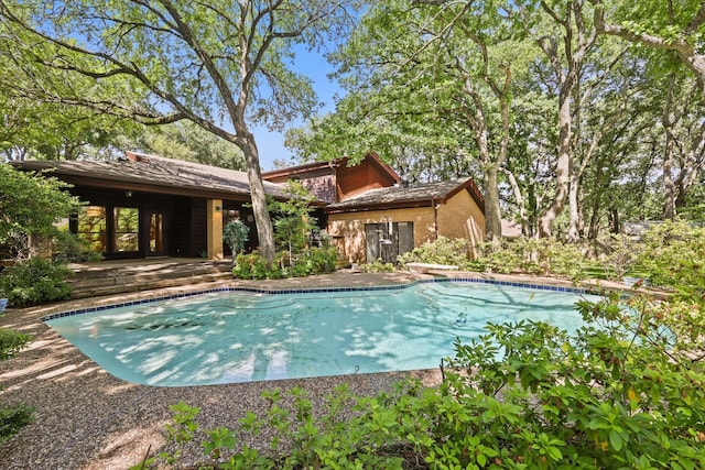 outdoor pool with a diving board and a patio