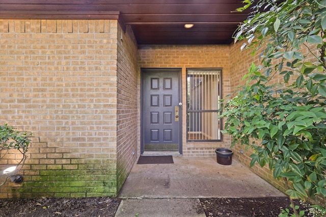 doorway to property with brick siding