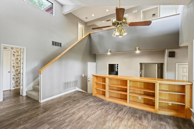 unfurnished living room with a ceiling fan, high vaulted ceiling, baseboards, stairs, and wood finished floors