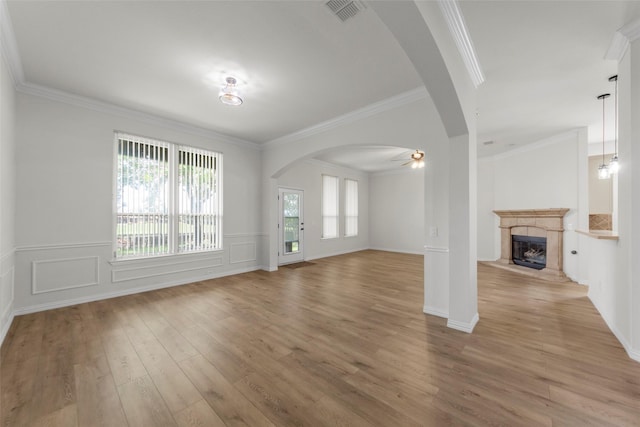 473 Inverness Dr, Fairview, TX 75069 - unfurnished living room featuring arched walkways, light wood-type flooring, ornamental molding, a premium fireplace, and a ceiling fan