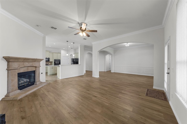 473 Inverness Dr, Fairview, TX 75069 - unfurnished living room with ceiling fan, arched walkways, light wood finished floors, crown molding, and a stone fireplace