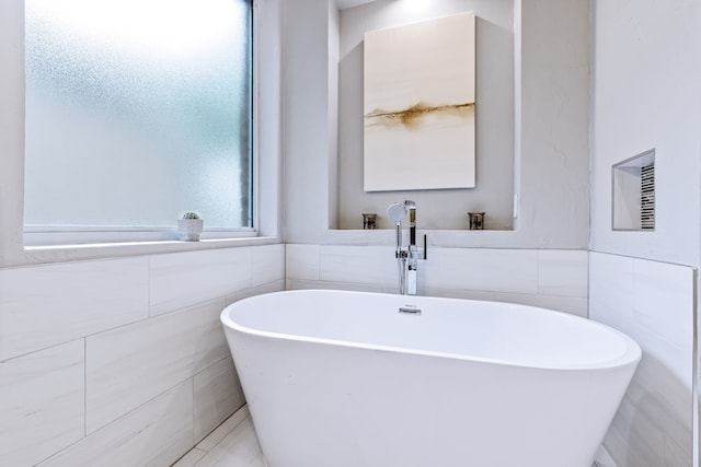 1430 Westmont Dr, Allen, TX 75013 - bathroom with tile walls, a freestanding bath, and a wainscoted wall