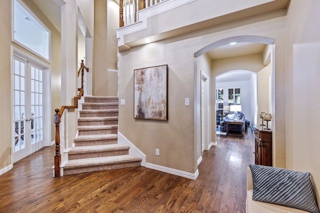 1430 Westmont Dr, Allen, TX 75013 - staircase with french doors, arched walkways, baseboards, wood finished floors, and a textured wall