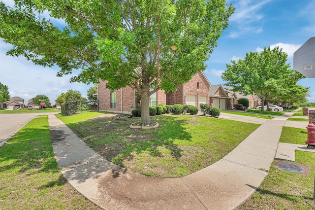 6904 Shoreway Dr, Grand Prairie, TX 75054 - view of front facade featuring brick siding, a front yard, driveway, and a garage