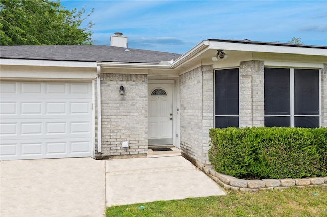 6405 Longmont Trl, Fort Worth, TX 76179 - view of exterior entry with a chimney, brick siding, and an attached garage