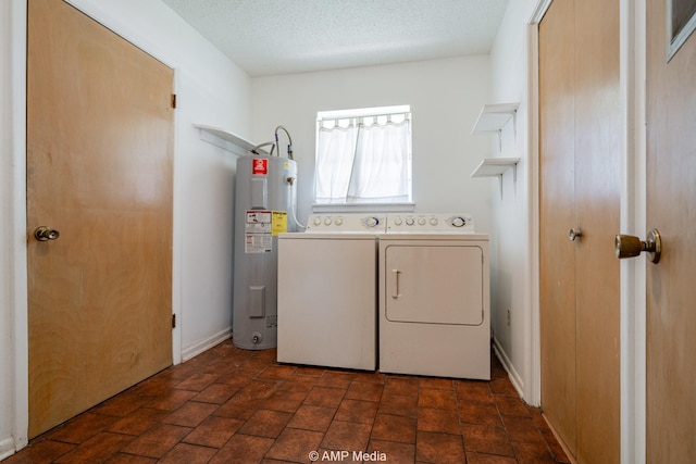 1201 New Hope Rd, Stamford, TX 79553 - laundry area featuring electric water heater, washer and clothes dryer, and a textured ceiling