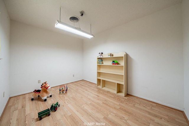 1201 New Hope Rd, Stamford, TX 79553 - spare room featuring wood finished floors, baseboards, and a textured ceiling