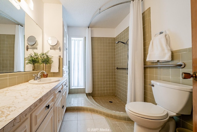 1201 New Hope Rd, Stamford, TX 79553 - bathroom with tile patterned flooring, toilet, tiled shower, vanity, and tile walls