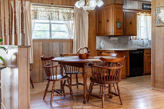 1201 New Hope Rd, Stamford, TX 79553 - dining space featuring wood walls, a chandelier, and light wood-style flooring