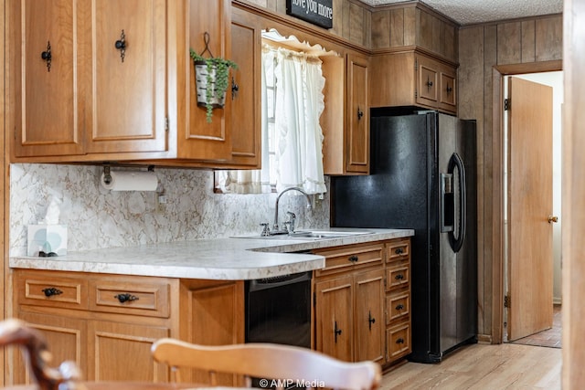 1201 New Hope Rd, Stamford, TX 79553 - kitchen with tasteful backsplash, light countertops, brown cabinetry, black appliances, and a sink