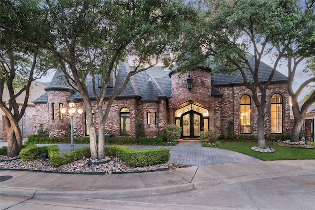 12229 Pecan Forest Dr, Dallas, TX 75230 - french country inspired facade with french doors, brick siding, curved driveway, and a high end roof