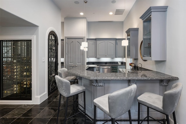 12229 Pecan Forest Dr, Dallas, TX 75230 - kitchen with gray cabinetry, a peninsula, dark stone counters, dishwasher, and wine cooler