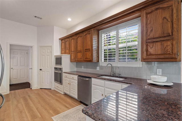 kitchen featuring a sink, appliances with stainless steel finishes, tasteful backsplash, light wood-style floors, and recessed lighting
