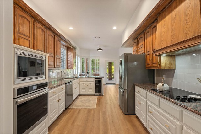 109 Sceptre Dr, Rockwall, TX 75032 - kitchen with appliances with stainless steel finishes, beverage cooler, custom exhaust hood, light wood-style floors, and backsplash