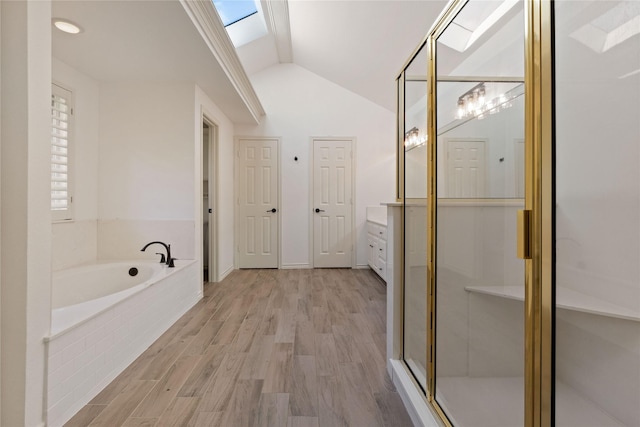 109 Sceptre Dr, Rockwall, TX 75032 - full bath featuring a skylight, vaulted ceiling, a bath, wood finished floors, and a shower stall