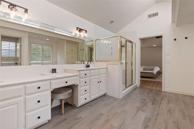 full bath with a stall shower, double vanity, wood finished floors, high vaulted ceiling, and ensuite bath