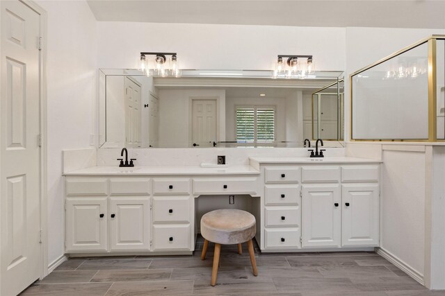 full bathroom with double vanity, wood finished floors, and a shower stall