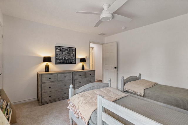 bedroom featuring light carpet, a ceiling fan, and baseboards