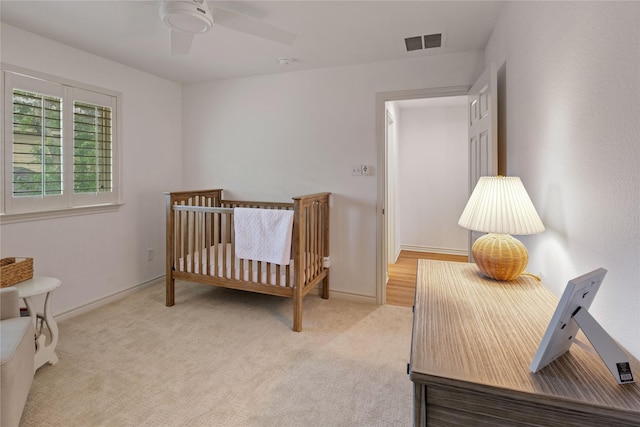 bedroom with light carpet, a ceiling fan, and baseboards
