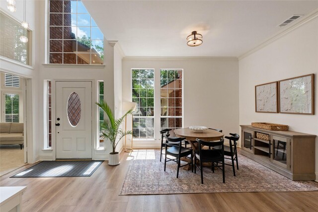 dining space featuring wood finished floors and crown molding
