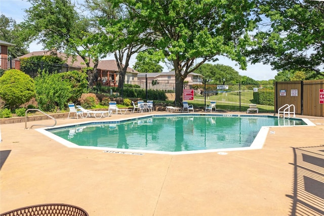 community pool with fence and a patio