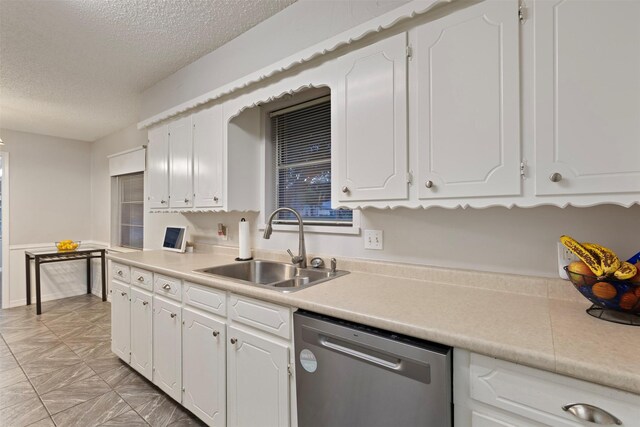 1317 Kingsbridge Dr, Garland, TX 75040 - kitchen featuring dishwasher, a sink, a textured ceiling, white cabinetry, and light countertops