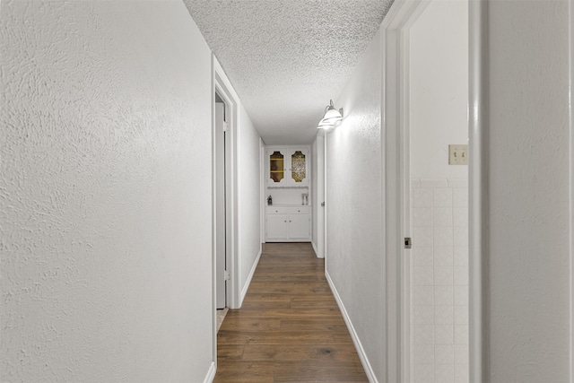 1317 Kingsbridge Dr, Garland, TX 75040 - hallway with a textured ceiling, dark wood-style floors, a textured wall, and baseboards