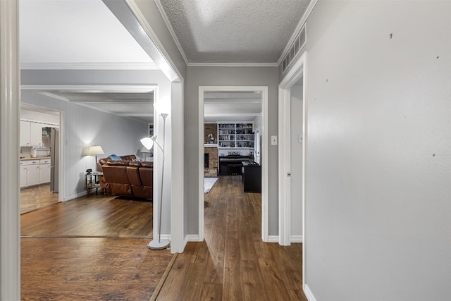 1317 Kingsbridge Dr, Garland, TX 75040 - hallway with hardwood / wood-style floors, a textured ceiling, baseboards, and crown molding