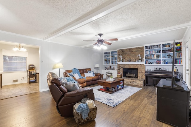 1317 Kingsbridge Dr, Garland, TX 75040 - living room with a textured ceiling, a ceiling fan, wood finished floors, a chandelier, and a fireplace