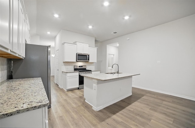 505 Pleasant Hill Ln, Fate, TX 75189 - kitchen featuring stainless steel appliances, a sink, decorative backsplash, white cabinetry, and light wood-style flooring