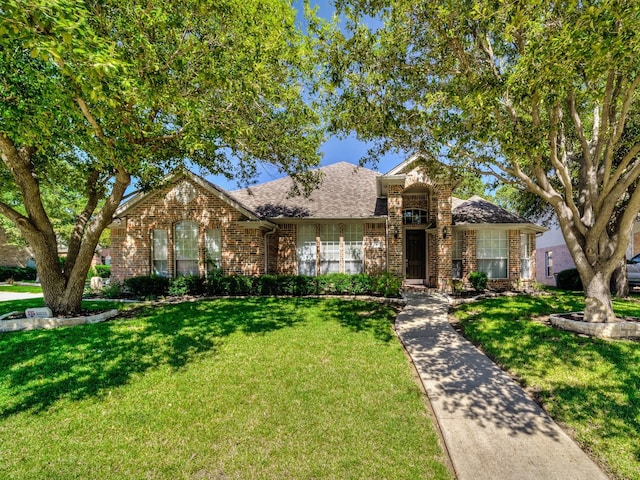 traditional-style home with brick siding and a front yard