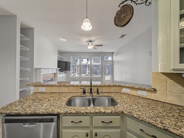 kitchen featuring dishwasher, a sink, a ceiling fan, tasteful backsplash, and stone counters