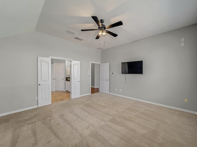 unfurnished bedroom with light carpet, baseboards, lofted ceiling, and a ceiling fan