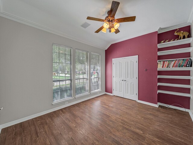 unfurnished bedroom featuring ornamental molding, wood finished floors, baseboards, a ceiling fan, and a closet