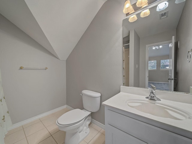 bathroom with toilet, vanity, tile patterned flooring, lofted ceiling, and baseboards